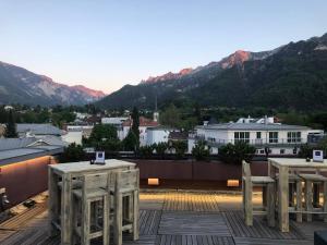 two tables on a roof with mountains in the background at Hotel Bayern Vital in Bad Reichenhall