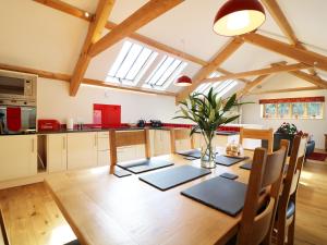 a kitchen and dining room with a wooden table at Old Armoury Barn in Ashburton