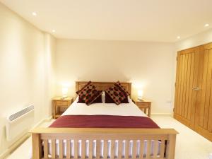 a bedroom with a large bed with two night stands at Old Armoury Barn in Ashburton