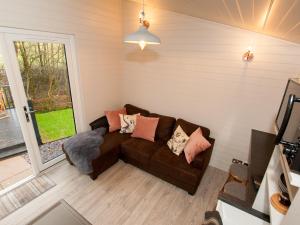 a living room with a brown couch with pillows at Reflection in Canonbie