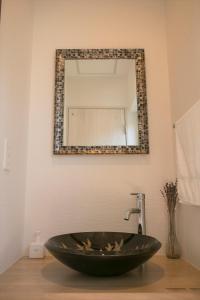 um lavatório de casa de banho com uma grande tigela preta em frente a um espelho em SORA 1 em Furano