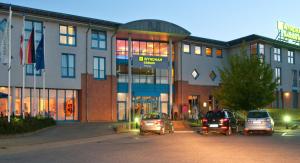 a building with cars parked in front of it at Wyndham Garden Wismar in Wismar