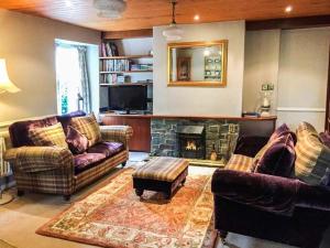 - un salon avec deux canapés et une cheminée dans l'établissement Gavel Cottage, à Bowness-on-Windermere
