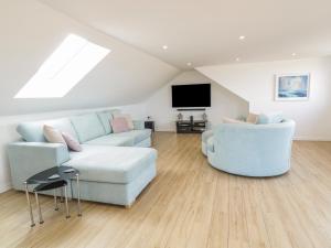un salon avec un canapé bleu et une télévision dans l'établissement Sunset View, à Newquay