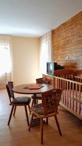 a dining room with a table and chairs and a crib at Apartmani Smiljanic Sokobanja in Soko Banja
