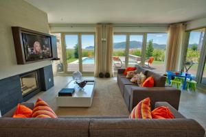a living room with two couches and a tv at Troia Residence by The Editory - Apartamentos Praia in Troia
