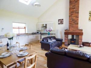 a living room with a couch and a table and a kitchen at Poppy Cottage in Lancaster