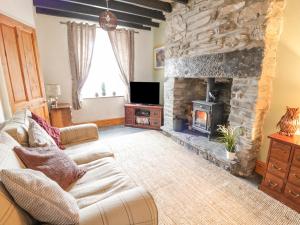 a living room with a couch and a stone fireplace at Preswylfa in Betws-y-coed