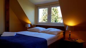 a bedroom with a bed with a blue blanket and a window at Apartament Lawenda in Łeba