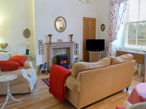 a living room with a couch and a fireplace at 3 Queen Marys Buildings in Jedburgh