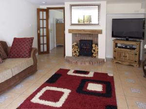 a living room with a couch and a fireplace at Rosewaters Cottage in Shrawley