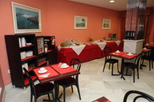 a dining room with red tables and chairs at Chaikana in El Puerto de Santa María