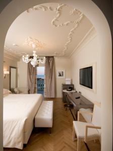 una camera da letto con un letto grande e una scrivania di Grand Hotel Da Vinci a Cesenatico