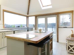 a kitchen with a large island with a counter top at Treetops in Fowey