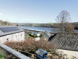 a view of a river with a house with solar panels at Treetops in Fowey