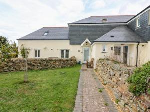 a white house with a stone wall and a stone path at Sorrel Cottage in Padstow