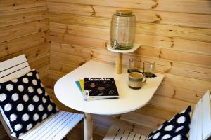 a small table with a book and two chairs at Marlborough Wine Barrel Cabins in Blenheim