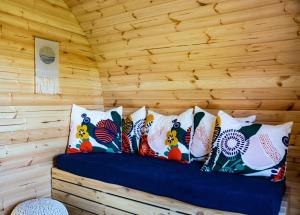 a bed in a log cabin with pillows on it at Marlborough Wine Barrel Cabins in Blenheim