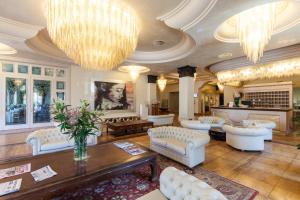 a large living room with white furniture and a chandelier at Palace Hotel in Milano Marittima