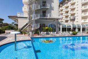 a swimming pool in front of a hotel with a water slide at Palace Hotel in Milano Marittima