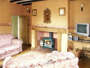 a living room with a fireplace and a tv at Pabo Lodge in Llandudno Junction
