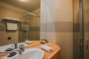 a bathroom with a sink and a shower at Balvanyos Resort (Grand Hotel Balvanyos) in Balvanyos