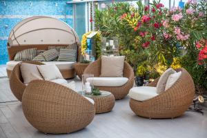 a patio with wicker chairs and a gazebo at Palace Hotel in Milano Marittima