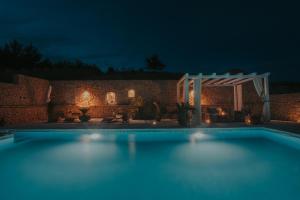 una piscina en un patio trasero por la noche en The Residence, en Šibenik