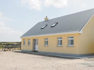 ein gelbes Haus mit grauem Dach in der Unterkunft Lakeview in Lettermore