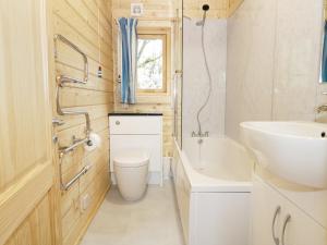 a bathroom with a sink and a toilet and a tub at The Shippen in West Chinnock