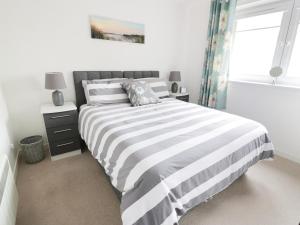 a bedroom with a black and white bed and a window at MACS Place in Largs