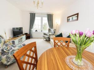 a living room with a table and a couch at MACS Place in Largs