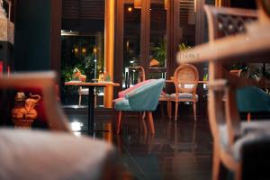 a room with chairs and a table in a restaurant at iuDia Hotel in Phra Nakhon Si Ayutthaya