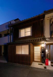 uma casa com um portão em frente em Miyabi Cosy House em Quioto