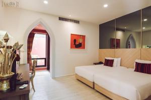 a bedroom with a large white bed and a window at iuDia Hotel in Phra Nakhon Si Ayutthaya