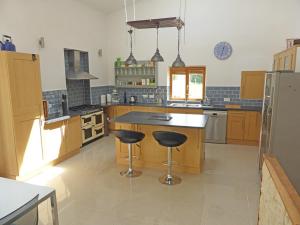 a large kitchen with two bar stools in the middle at Gite les Fleurs in Eymet