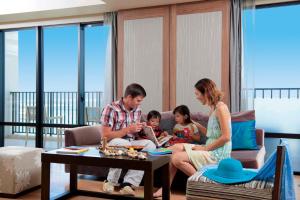 a family sitting on a couch in a living room at Moon Ocean Ginowan Hotel & Residence in Ginowan +200 photos