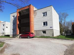 ein rotes Auto, das vor einem Gebäude parkt in der Unterkunft Vabaduse Apartment in Kärdla