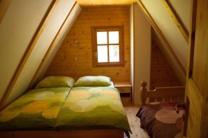 1 dormitorio con 1 cama en una habitación pequeña en Cottages Kravanja, en Trenta