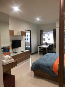 Dormitorio con cama, escritorio y TV en Smart Mansion en Min Buri