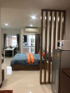 1 dormitorio con 1 cama con marco de madera en Smart Mansion, en Min Buri