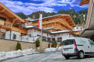 a white van parked in front of a building at Hotel Aschauer Hof z'Fritzn in Kirchberg in Tirol