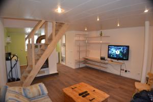 a living room with a staircase and a tv at Kajaka Beach Area Holiday Home in Pärnu