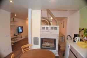 a living room with a fireplace and a table at Kajaka Beach Area Holiday Home in Pärnu