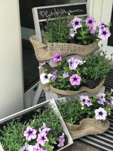 un groupe de fleurs violettes dans des paniers sur une chaise dans l'établissement Hotel Cascade Superior, à Düsseldorf