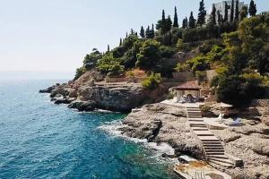 a resort on a cliff next to the ocean at Pyrgi Spetses in Spetses