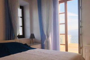 a bedroom with a bed and a large window at Pyrgi Spetses in Spetses
