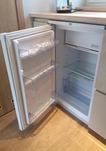 an empty refrigerator with its door open in a kitchen at Apartamenty-Obok 1 in Zator