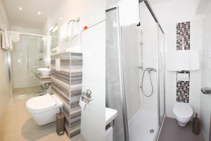 a white bathroom with a toilet and a shower at Hotel Galija in Pula +77 photos