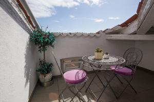 einen kleinen Balkon mit einem Tisch und 2 Stühlen in der Unterkunft Hotel Galija in Pula